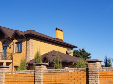 Açık mavi gökyüzü, yan görünüm altında modüler baca ile yeni tuğla ev