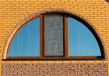 Half-round window in brick wall, house exterior, closeup clipart