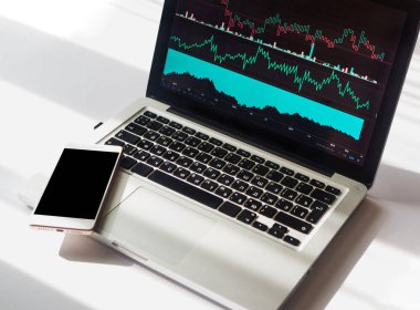 İş üstünde laptop, kopya alanı ile telefon görüntülenen çeşitli göstergeler ile grafik grafikler. Çalışma alanı kavramı