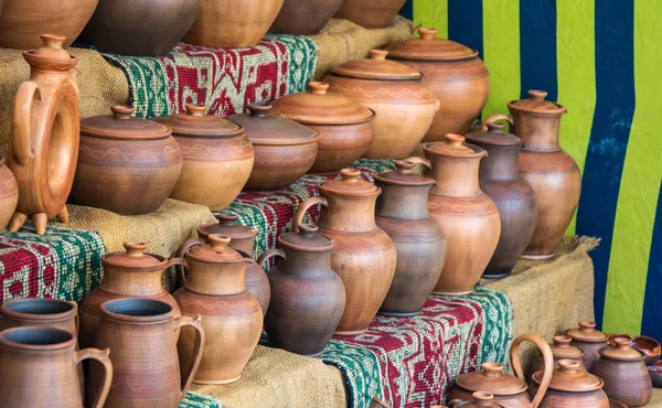 Clay pots at pottery shop in the street, close-up. Handmade earthenware