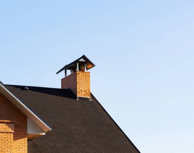 Küçük çatı çatı üst müesseseden, closeup ile soyulmuş tuğla baca