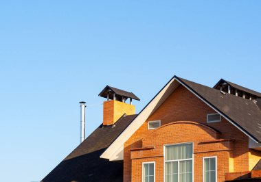 Tuğla baca mavi gökyüzü, evin cephe altında çok düzeyli çatıda