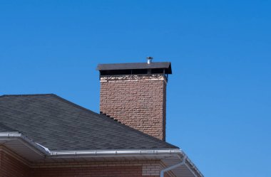 Güzel forge ile modern tuğla baca. Açık mavi gökyüzü arka plan