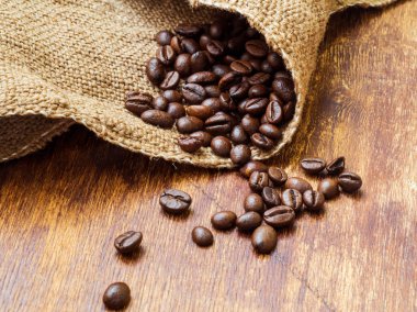 Kahve çekirdekleri tutuyordu, ahşap arka plan üzerinde yakın çekim