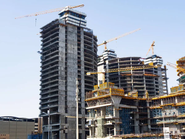 Modern yüksek katlı binalar İnşaat vinçleri ve iskele ile