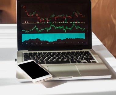 Telefonu ve laptop ile iş ve finansal grafik ekran üzerinde. Uzay Smartphone cep telefonu ile kopyalayın. Analiz iş rapor, istatistik kavram