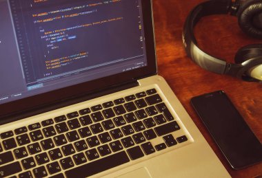 Cep telefonu ve kulaklık çalışma yeri ile dizüstü bilgisayarınızın ekran üzerinde PHP kodu