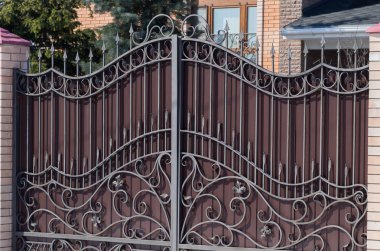 Gündüz vakti bir desen ve tuğla sütunlarla şık kahverengi Iron gate