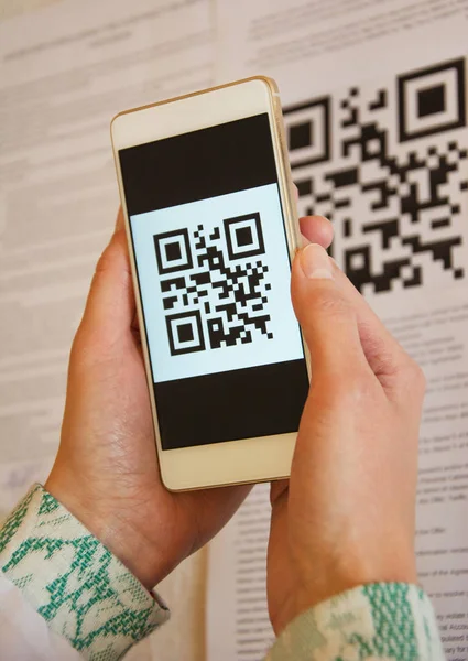 Two woman hands scanning QR code using mobile smart phone