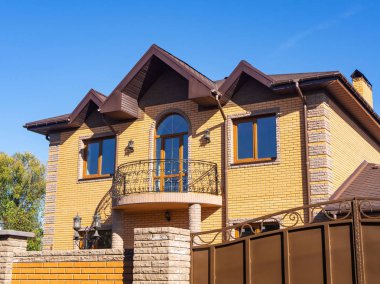 Modern yazlık balkon ve tuğla cepheli güneş ışığı altında. Mavi gökyüzü arka plan