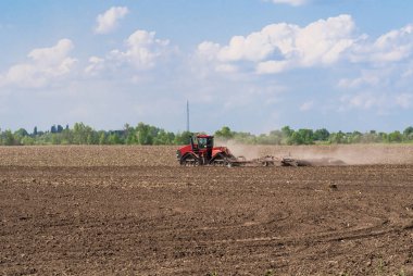 Tohum ekmeden önce tarıma elverişli arazi yetiştiriyor. Çiftlikte çalışan traktör, modern bir tarım taşımacılığı.,