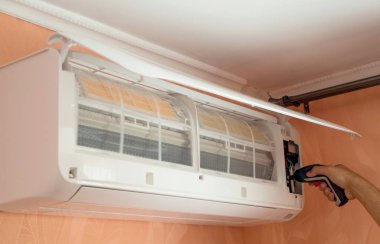 Elektrikli tornavida kullanarak duvar üzerinde Klima tamiri