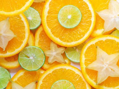 Narenciye meyve dilimleri arka plan. Dilim limon, portakal ve carambola yıldız zemin. Portre ve doku, üstten görünüm.