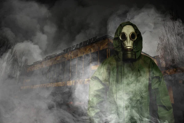 Człowiek w maskę przeciwgazową i płaszcz dla ochrony chemicznej przed opuszczonym budynku — Zdjęcie stockowe