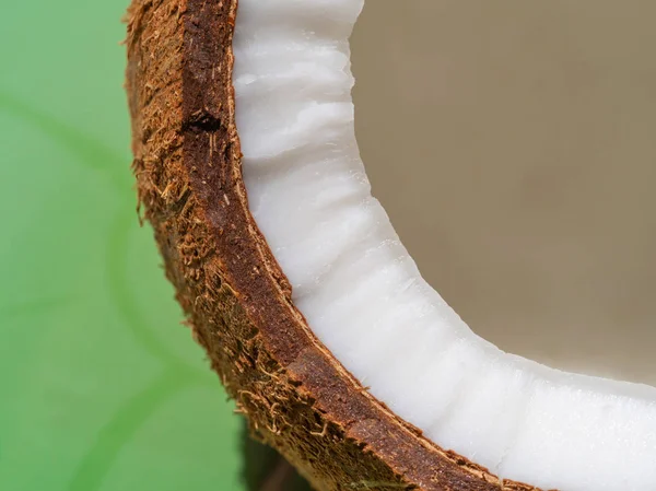 Primer plano de medio corte de coco sobre fondo verde, enfoque selectivo — Foto de Stock