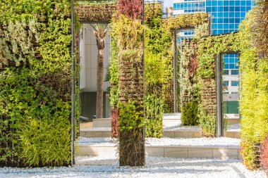 Modern landscape design. Rectangular metal frames like doors covered with green vegetation clipart