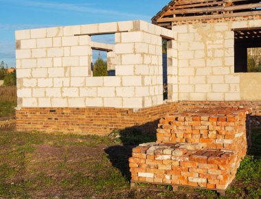 Grup günbatımı, evin arka planda yapım aşamasında Palet üzerindeki kullanılan tuğla dizilmiş