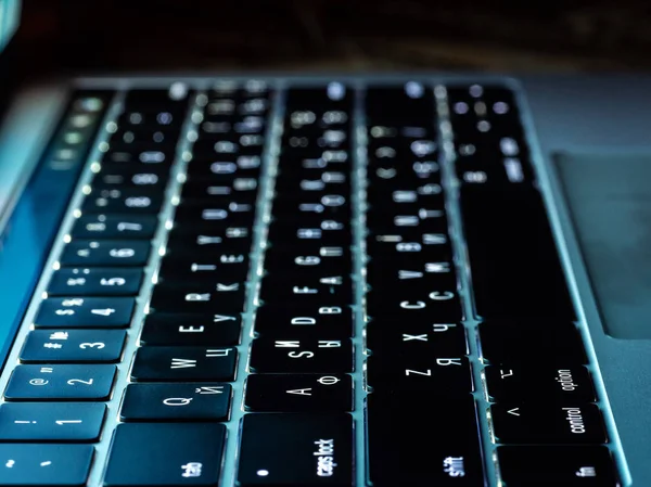 Fechar o teclado do portátil preto com retroiluminação, vista lateral — Fotografia de Stock