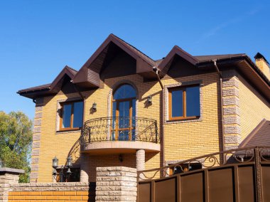Pencereli tuğla bina ve sahte balkon. Berrak mavi gökyüzü 