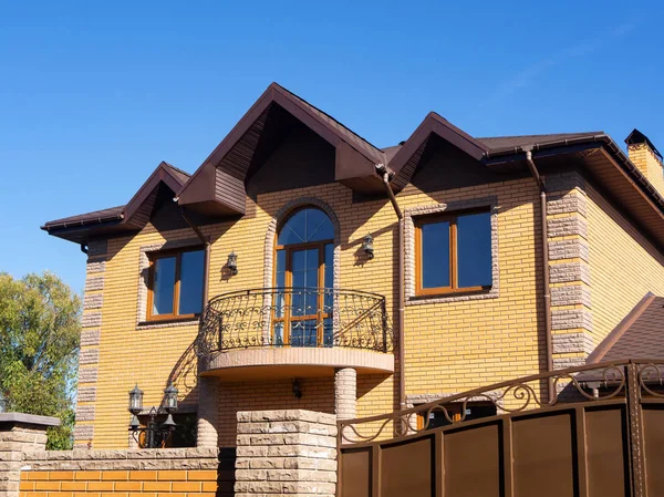 Pencereli tuğla bina ve sahte balkon. Berrak mavi gökyüzü 