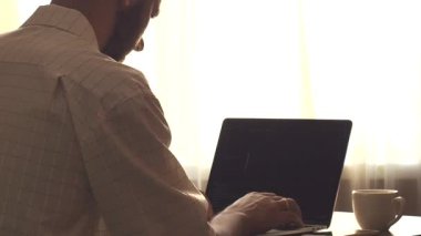 Genç programcı iş yerinde dizüstü bilgisayarda kodlama yapıyor.