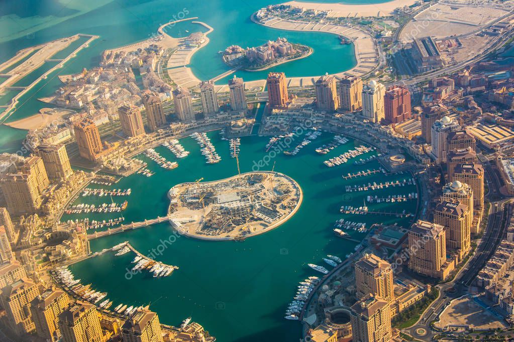 Rich real estate Pearl-Qatar island in Doha through the airplane porthole. Qatar, the Persian Gulf, aerial view