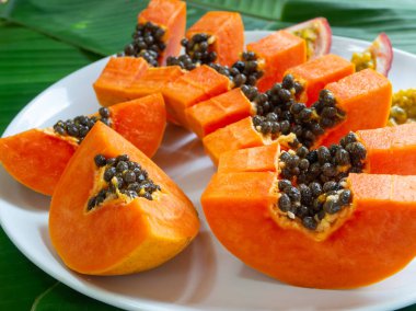 Papaya parçalarının makrosu. Beyaz tabakta egzotik ve tropikal meyveler. Yaz saati