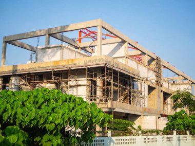 Beton ve beyaz köpük bloklardan yapılmış modern yapı inşaatı. Bir sürü iskele. Yaz aylarında inşaat
