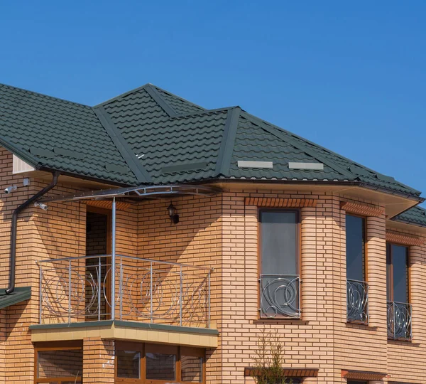 Casa moderna con balcón y fachada de ladrillo. Fondo cielo azul — Foto de Stock