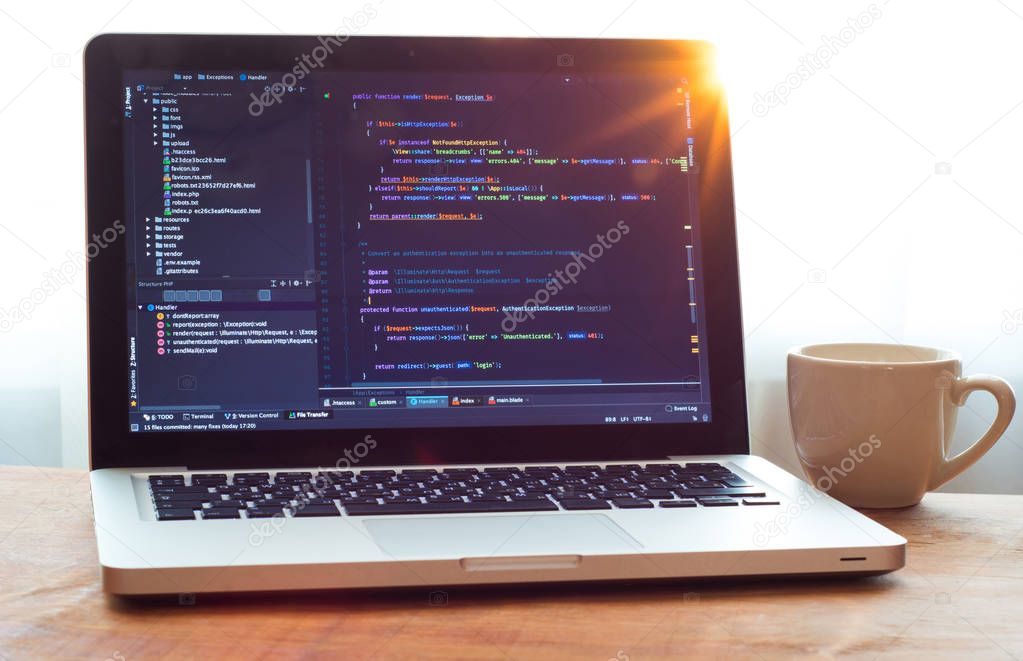 Php code on laptop (web developing) and white mug in sunlight