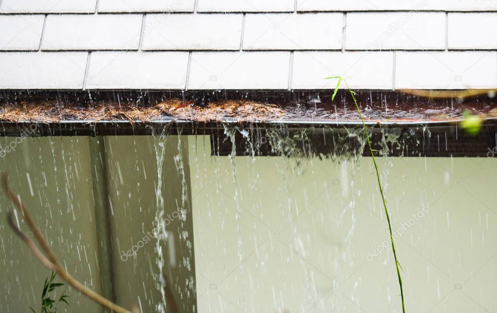 Close up view on clogged Rain Gutter in the rain. Home Guttering, Gutters
