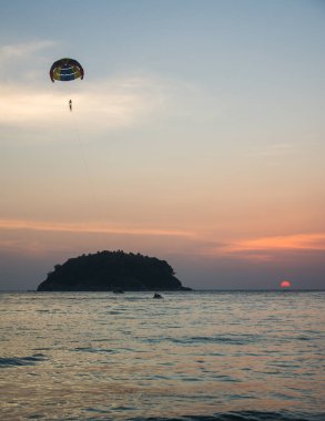 Gün batımı arka plan, ekstrem sporlar ile Kata plajda Parasailing Siluet