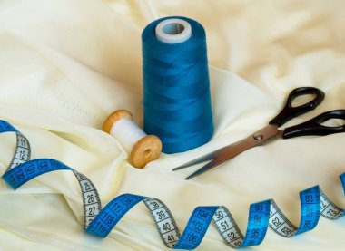 Bej tekstilde siyah makas, iplik ve bant ölçüsü, sewin