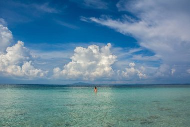 Bulutlu gökyüzü altında turkuaz suda genç kadın, Andaman deniz