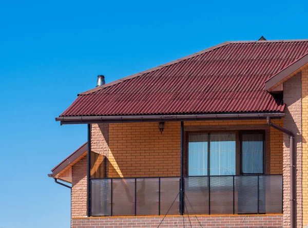 Modern stuga med balkong och tegelfasad. Blå himmel bakgrunds — Stockfoto
