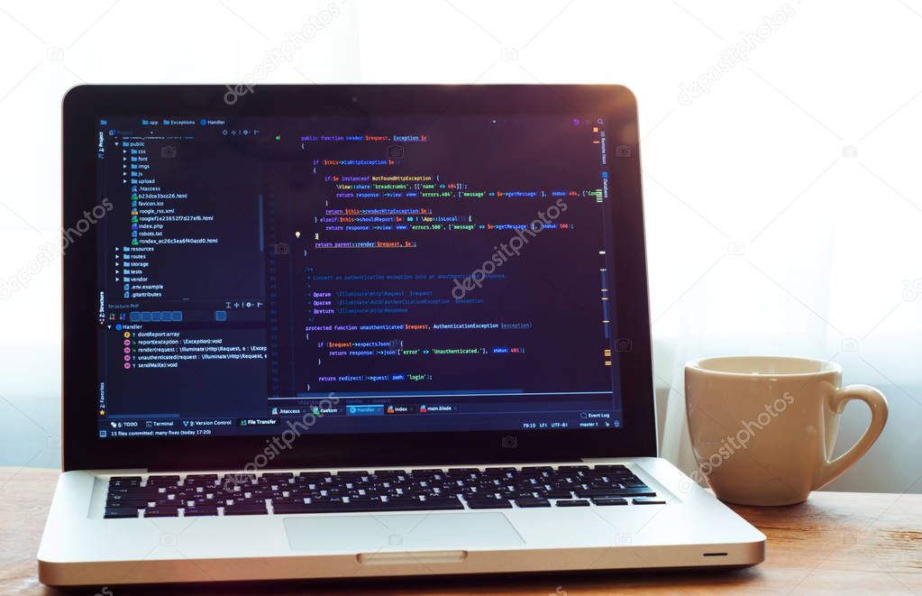 Php code on laptop (web developing) and white cup. Programmer workplace