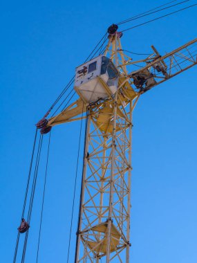 Mavi gökyüzüne karşı sarı inşaat kulesi vinç, alt görünümü
