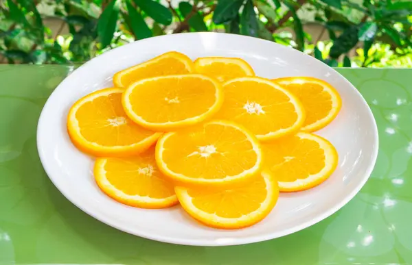 Close up shot of orange slices on white plate. Healthy and vegetarian eating — Stock Photo, Image