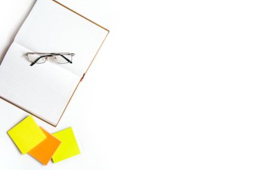 Üzerinde gözlük ve beyaz arka plan üzerindeki mesajlar için çıkartmalar olan açık defter. Düz yatıyordu. Metin için yer