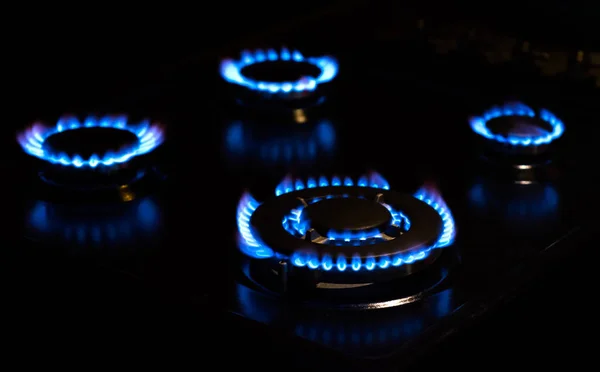 Négy kék lángjai gáztűzhely a sötétben — Stock Fotó