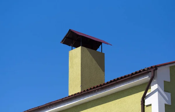 Skorstenen på taket. Klarblå himmel bakgrund — Stockfoto