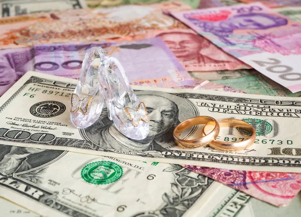 High heels and wedding rings on different currencies. Marriage o — Stock Photo, Image