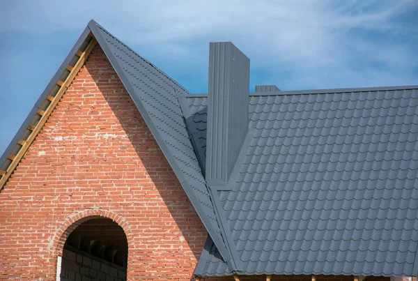 Casa de ladrillo con techo de baldosas de metal gris, agujero para ventana —  Fotos de Stock