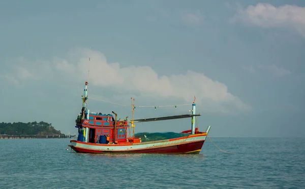 Primo piano della barca da pesca rossa con rete ormeggiata nel mare calmo vicino alla spiaggia — Foto Stock