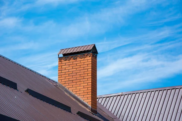 Brick chimney with beautiful forging and snow guards on the rooftop — Stock Photo, Image