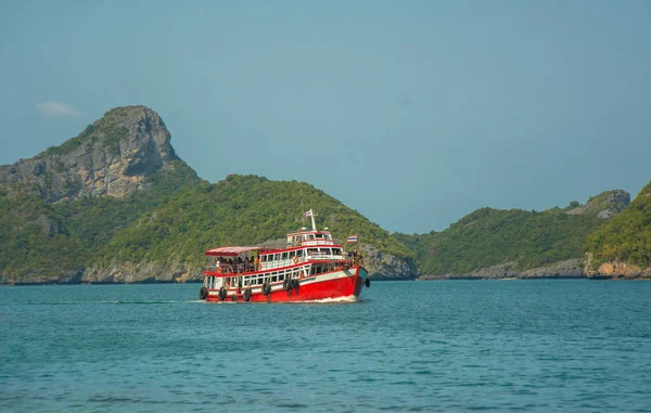 Big red ship for weekend cruise with tourists on board sail by sea among tropical islands — Stock Photo, Image