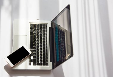 Dizüstü bilgisayar ve telefon güneş ışığında kopya alanı ile. Biraz ch görme