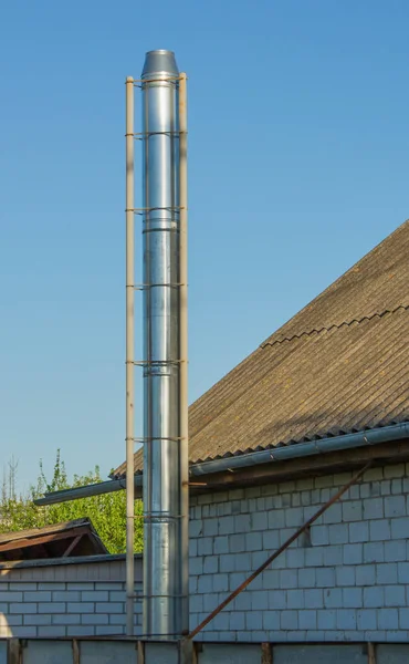 蓝色背景上长长的现代不锈钢烟囱 — 图库照片
