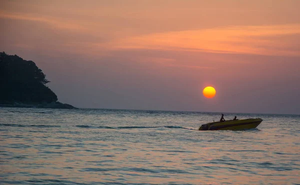Silhouettes de deux hommes sur le bateau dans la mer au coucher du soleil — Photo