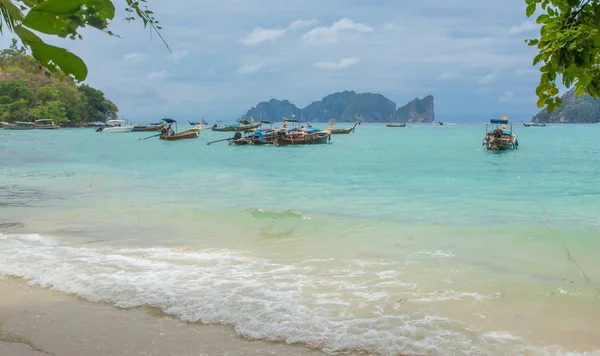 Beach with long tale taxi boats in turquoise water and mountains — Stock Photo, Image